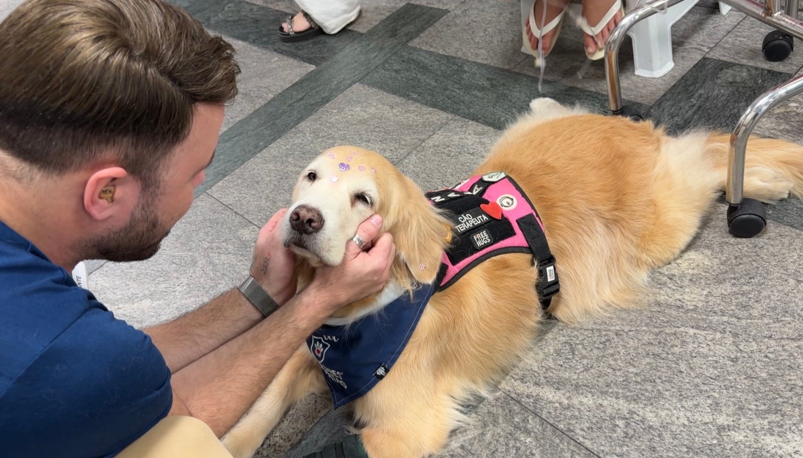 Tutor fazendo carinho em um dos cães do Unipet, a Nala.